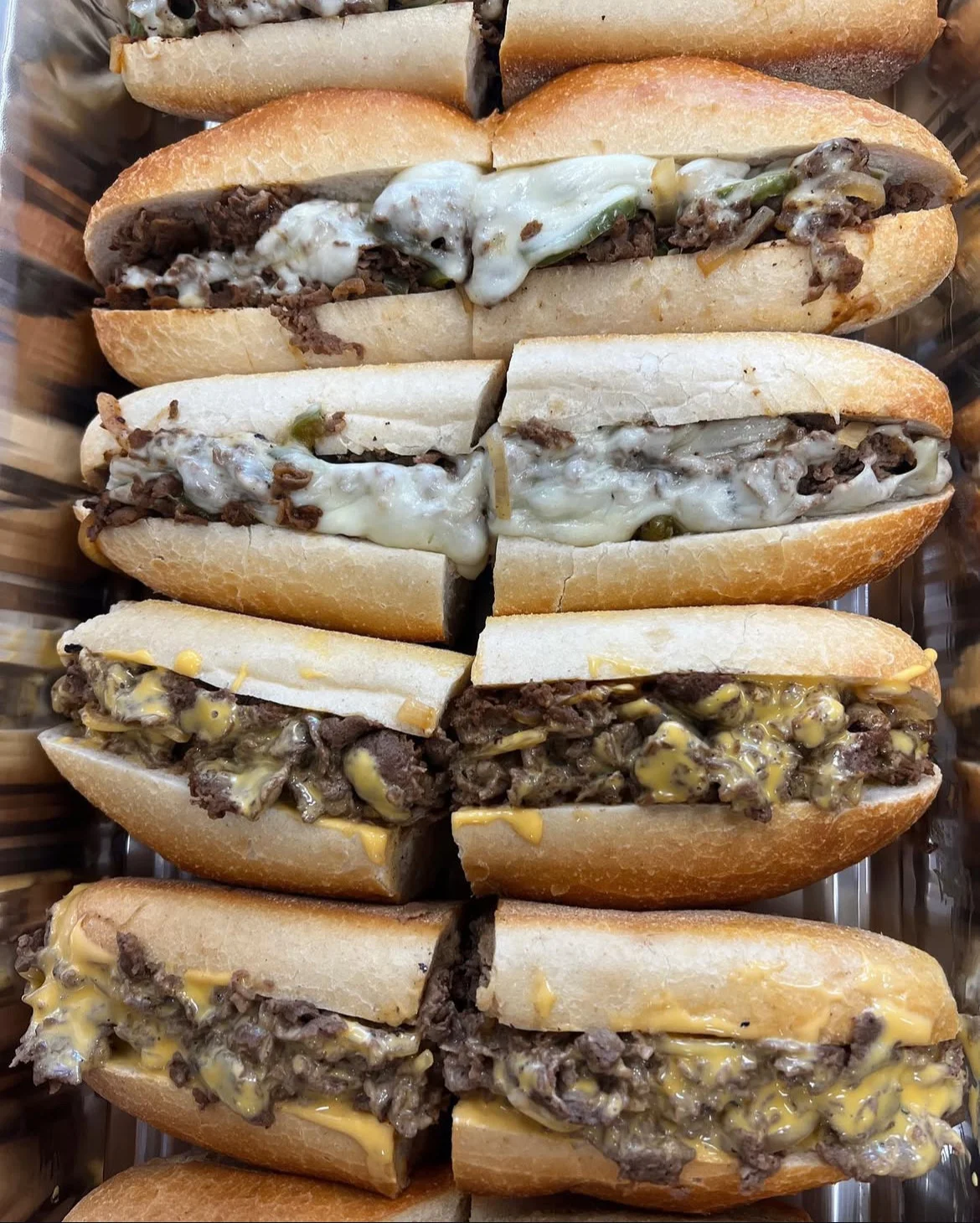 Delicious cheesesteak sandwiches stacked in a tray