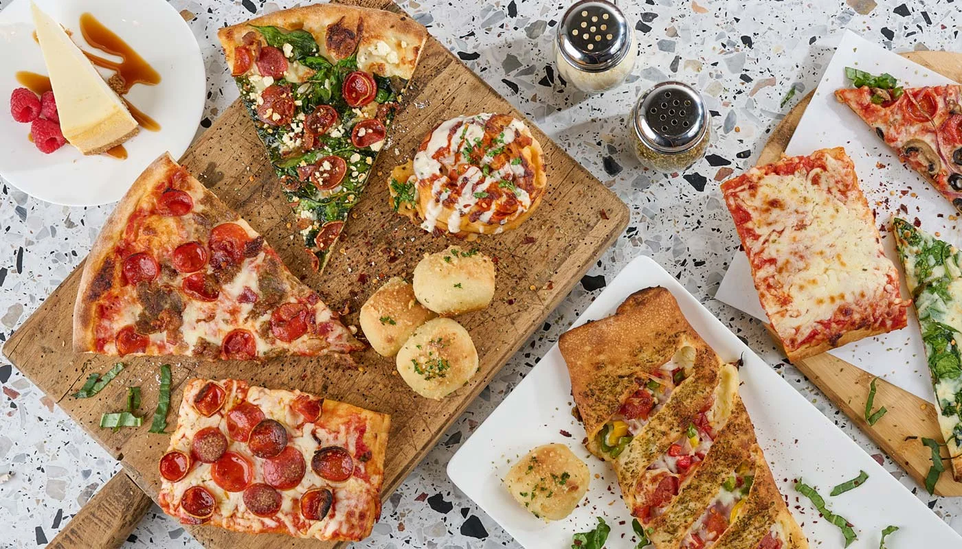Variety of pizzas including pepperoni and veggie on wooden boards