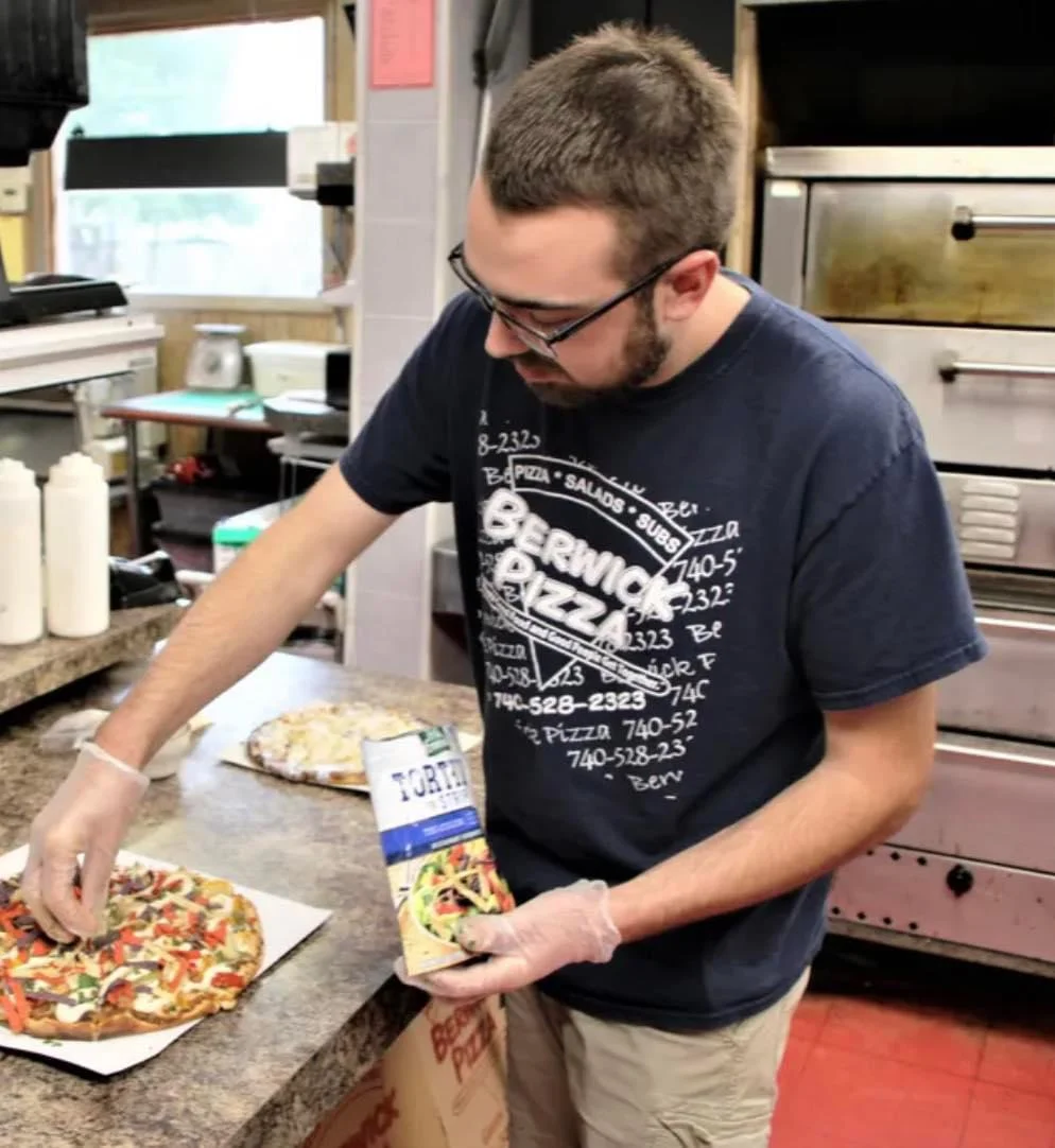 Pizza being prepared in a pizzeria kitchen