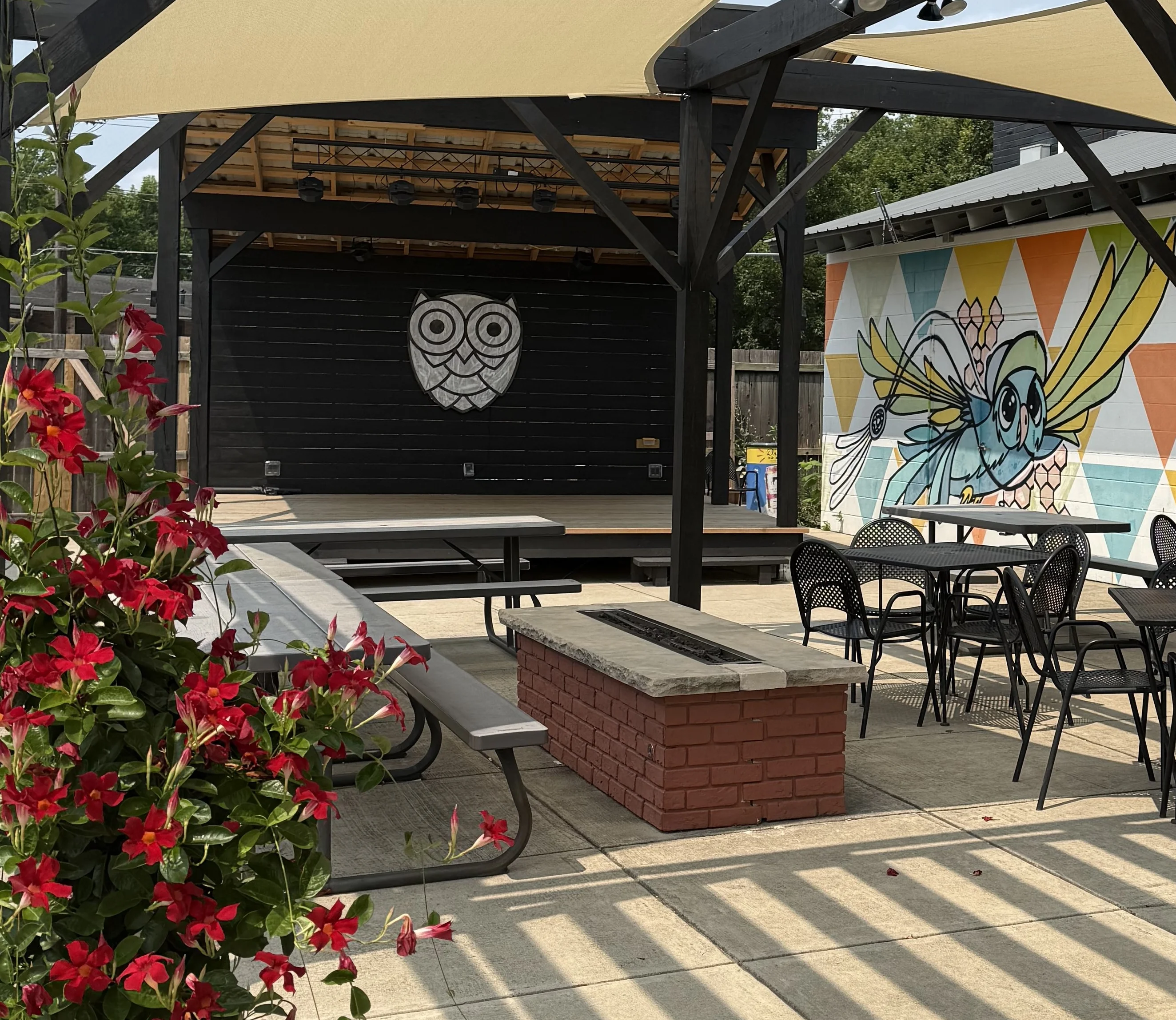 Outdoor dining area with colorful umbrellas and lawn games