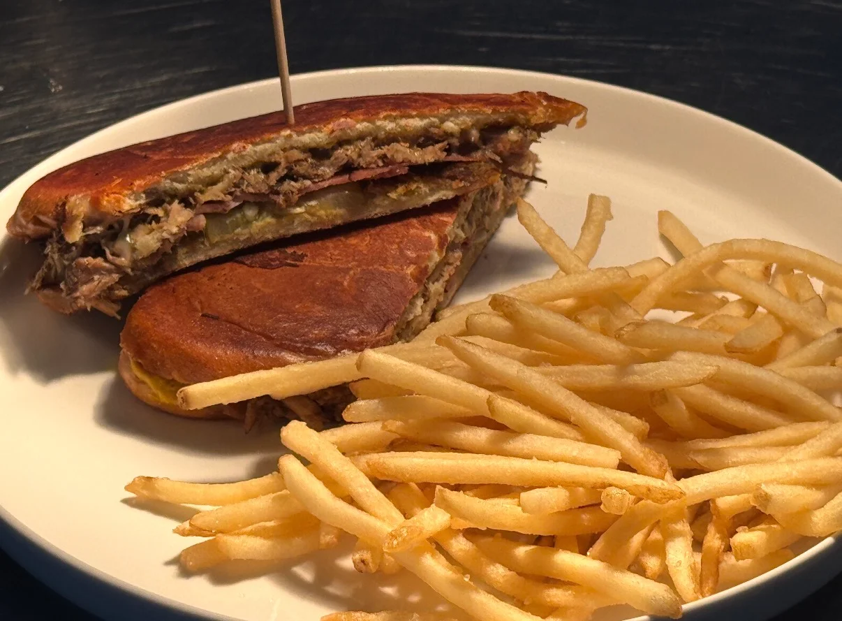 Cuban sandwich with fries on a white plate