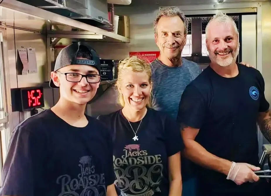 Smiling restaurant staff posing together in a commercial kitchen