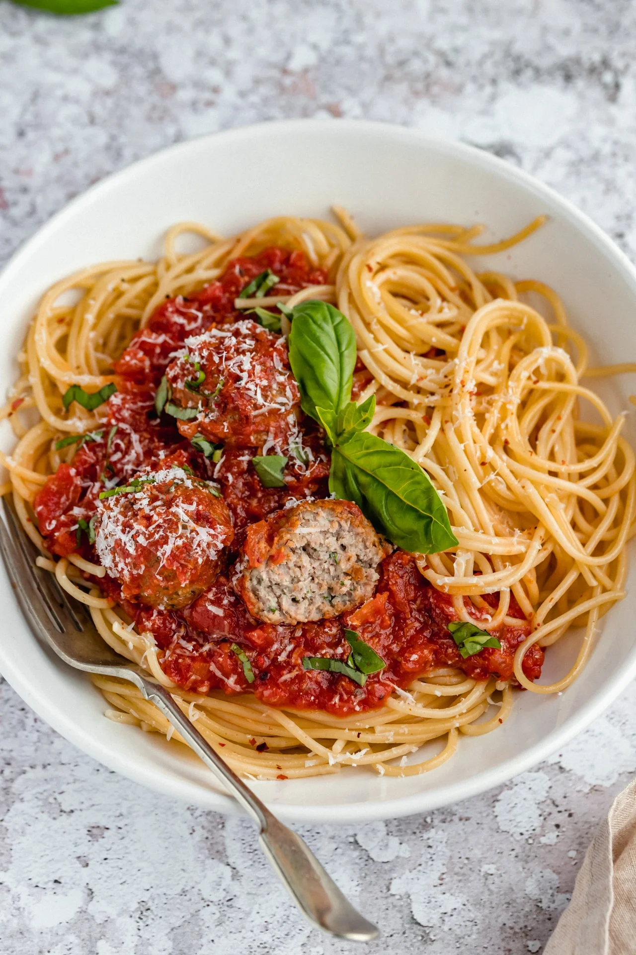 Classic spaghetti and meatballs in marinara sauce with fresh basil