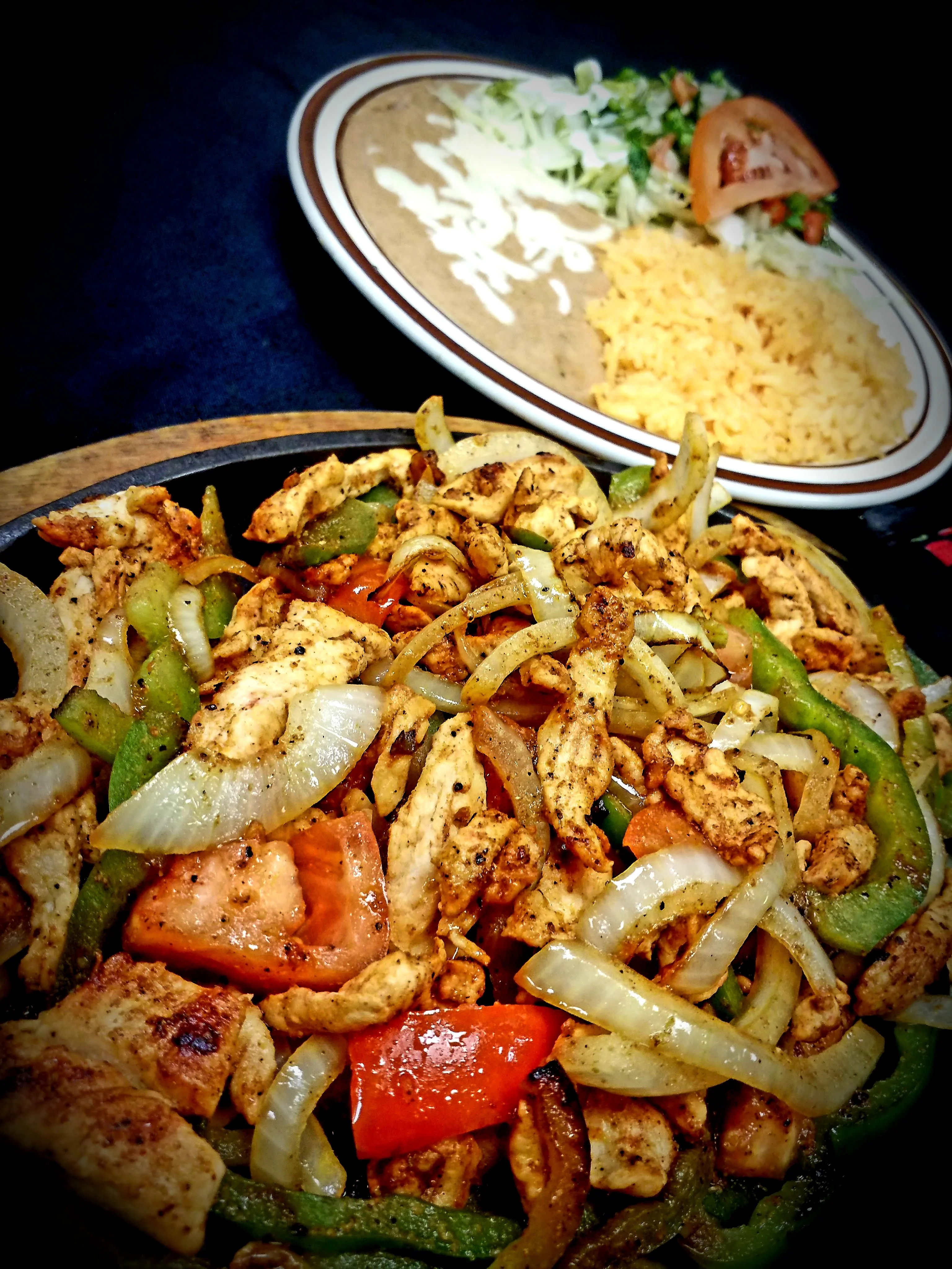 A sizzling plate of Chicken Fajitas with tender grilled chicken strips, onions, tomatoes, and green peppers, all perfectly seasoned and served hot. The best fajita in Radford.