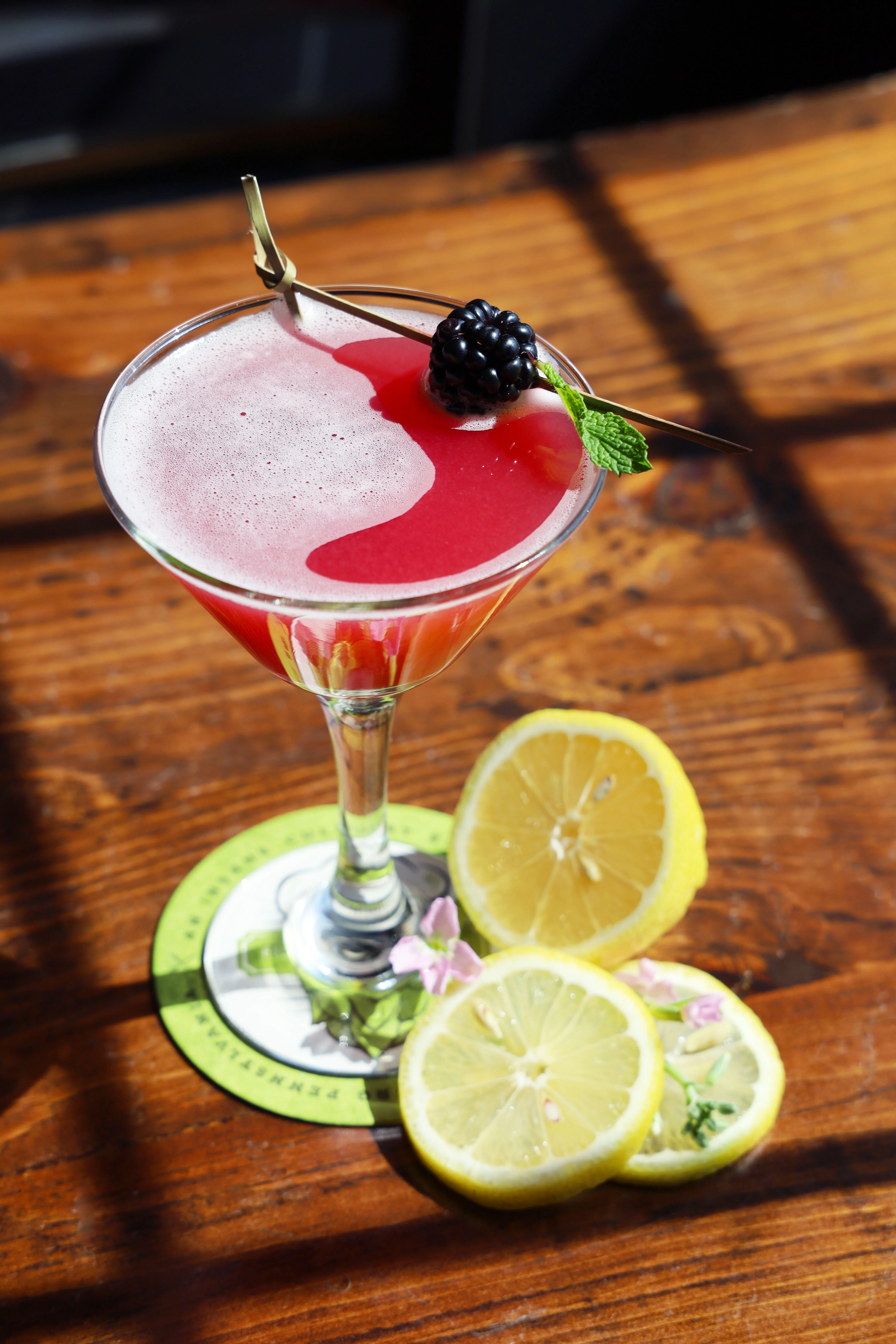 A refreshing blackberry cocktail garnished with a lemon twist.