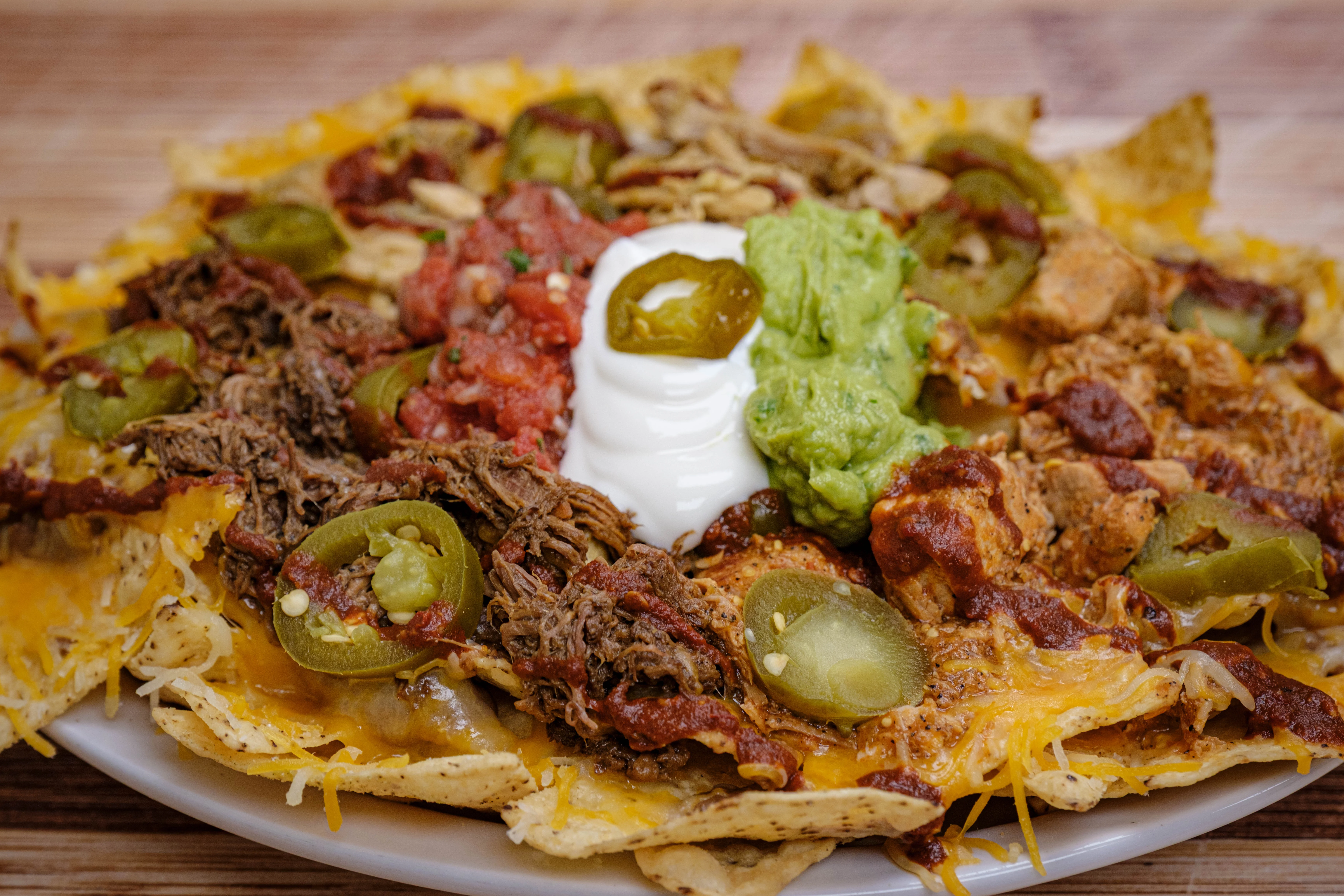 Delicious gourmet Taco Dips with fresh toppings on a wooden table