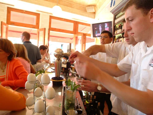 Bartenders preparing cocktails at a lively bar counter