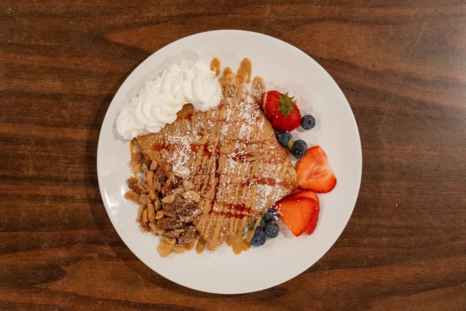 Delicious French crepes with berries and whipped cream