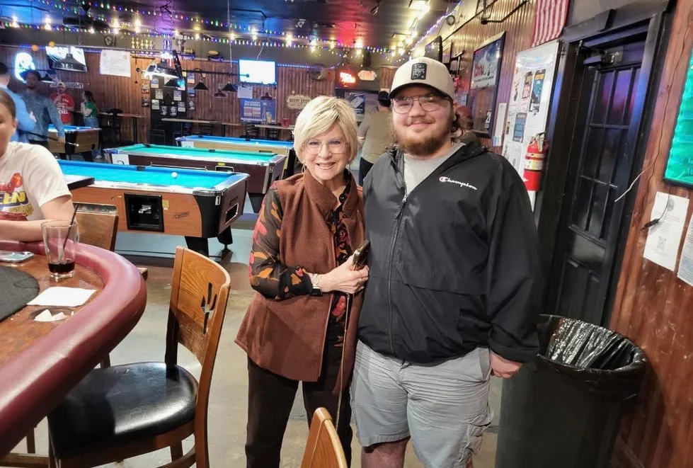 Friendly gathering in a lively bar with pool tables and warm lighting