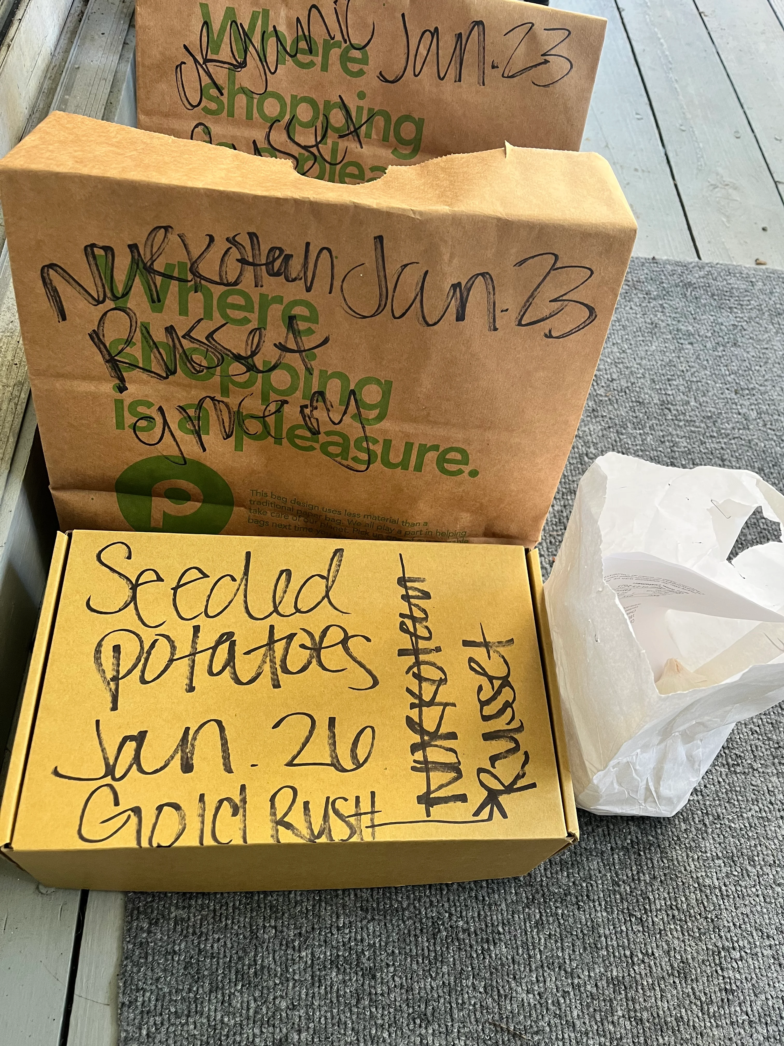 Boxes of seed potatoes labeled for planting