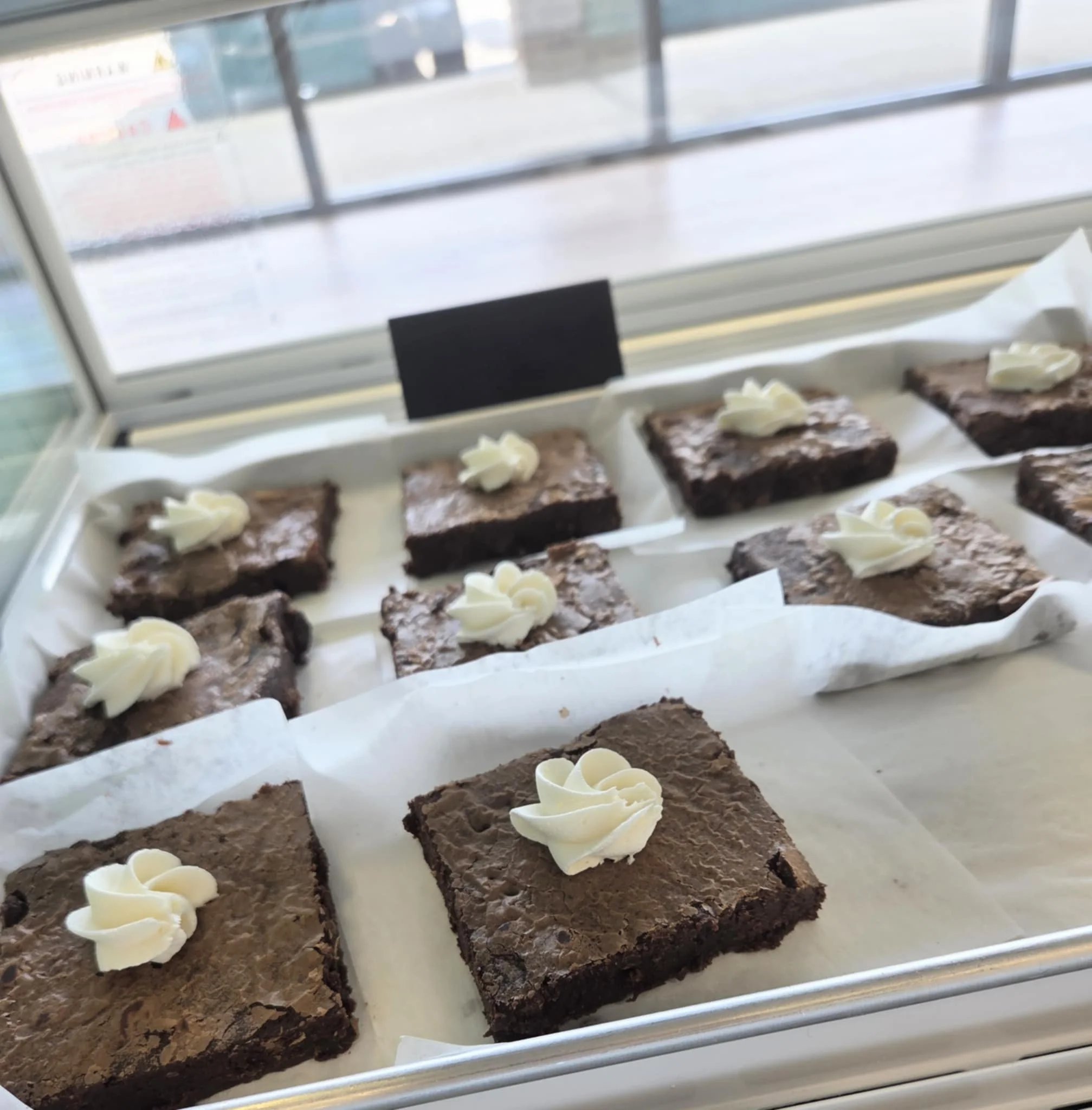 Decadent chocolate brownies with whipped cream rosettes