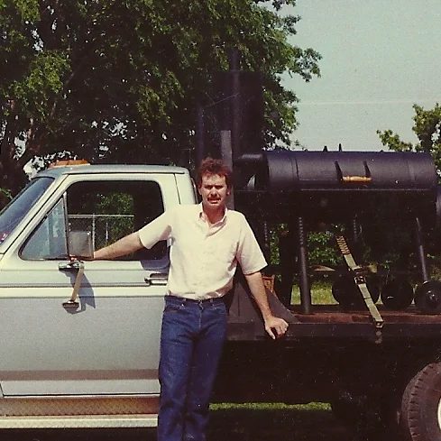 Vintage truck with a barbecue smoker in a grassy area