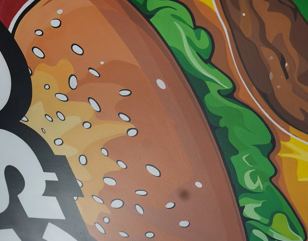 Colorful mural of a cheeseburger in a casual dining setting