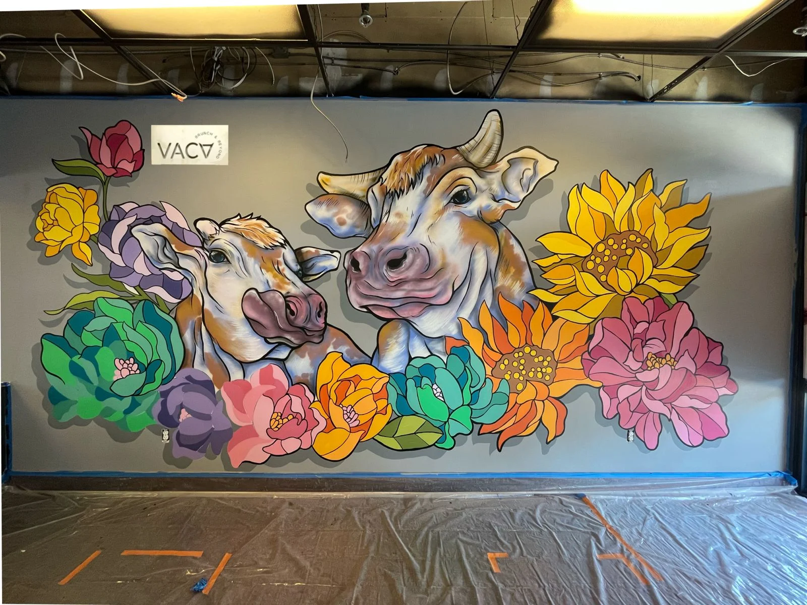 Colorful mural of cows and flowers in a restaurant interior
