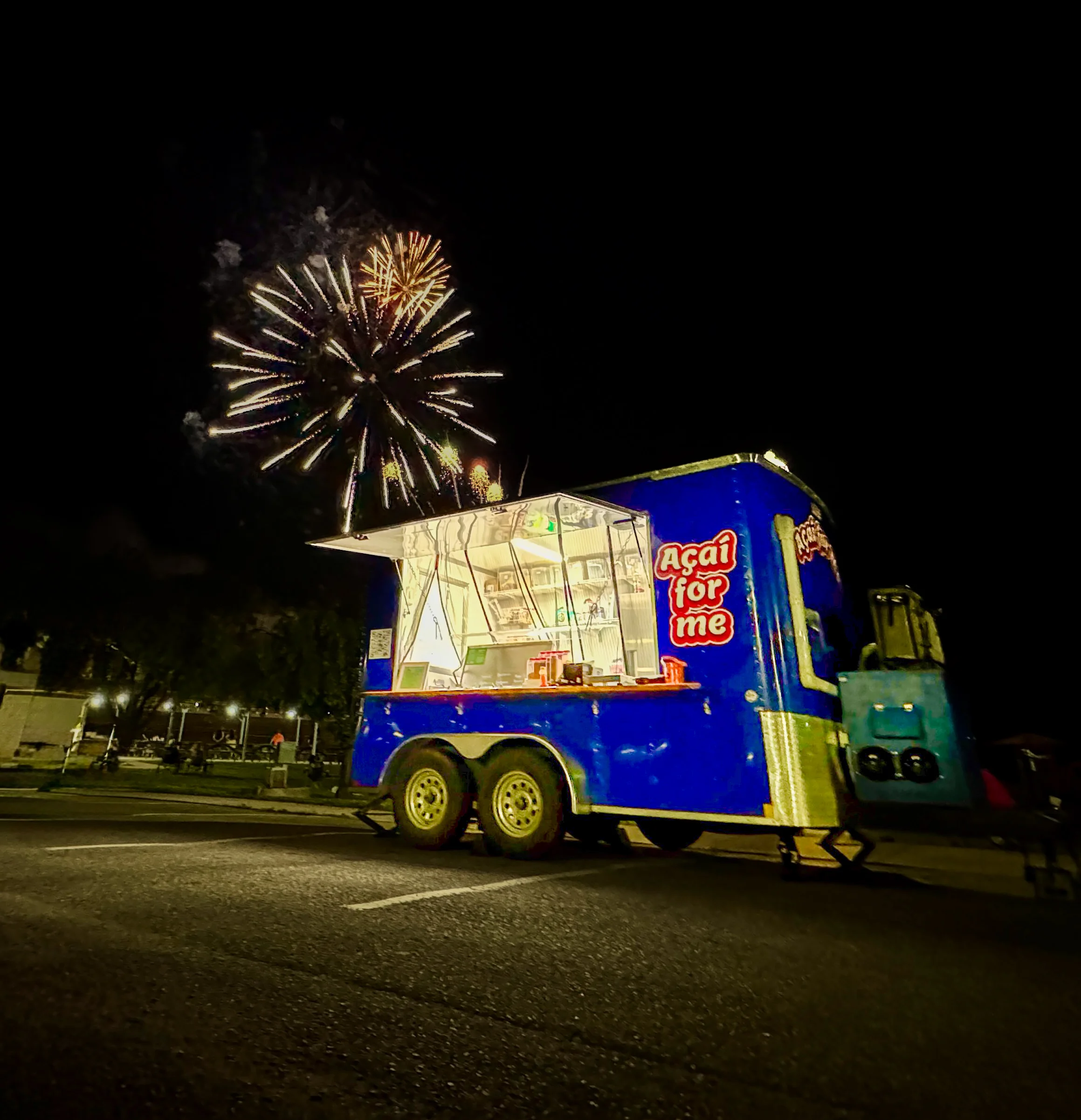 Colorful food truck with fireworks in the background