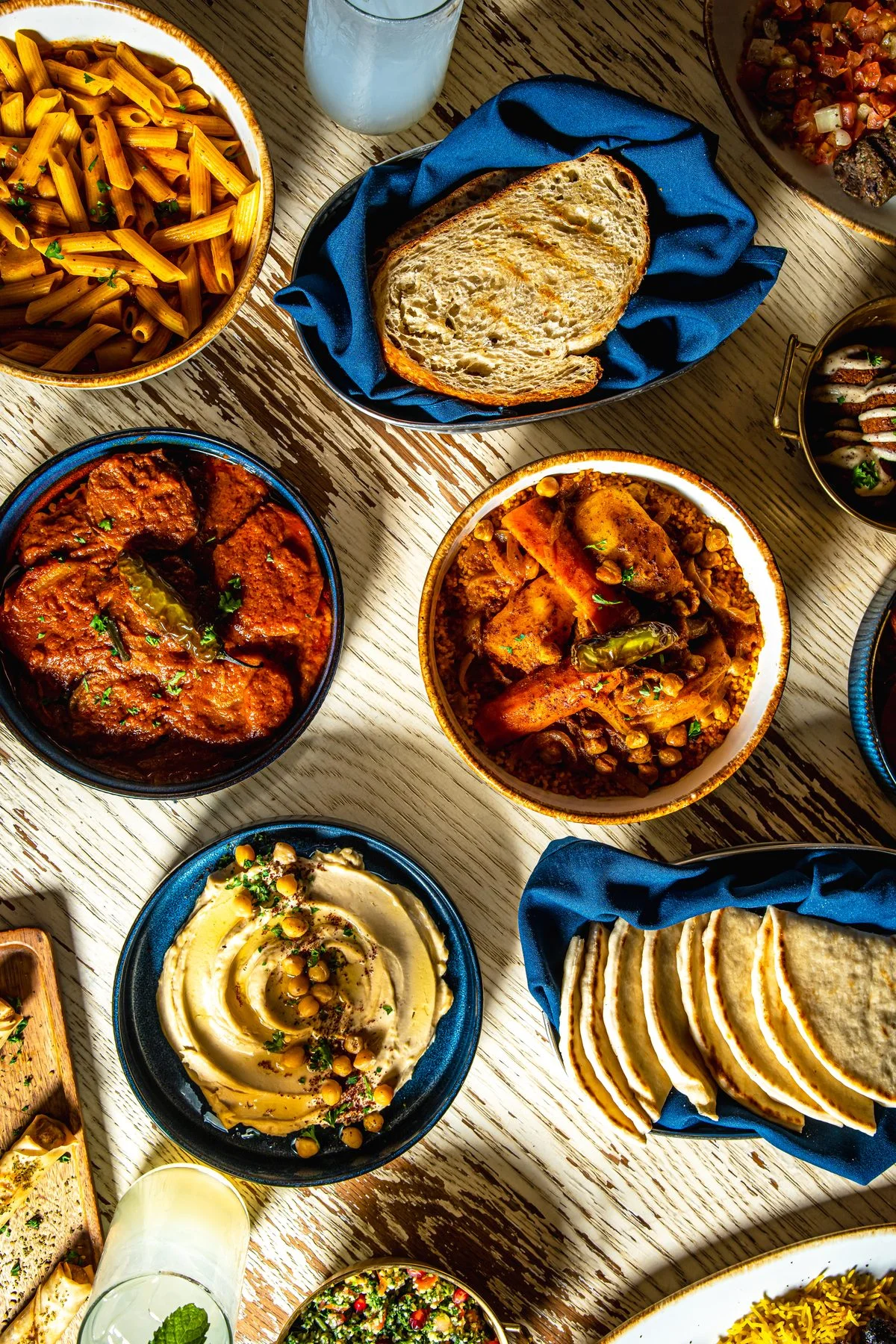 Overhead spread of Middle Eastern mezze with hummus, pita, kebabs, and spiced dishes