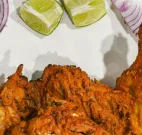 Tandoori chicken served with green chutney and lime wedges