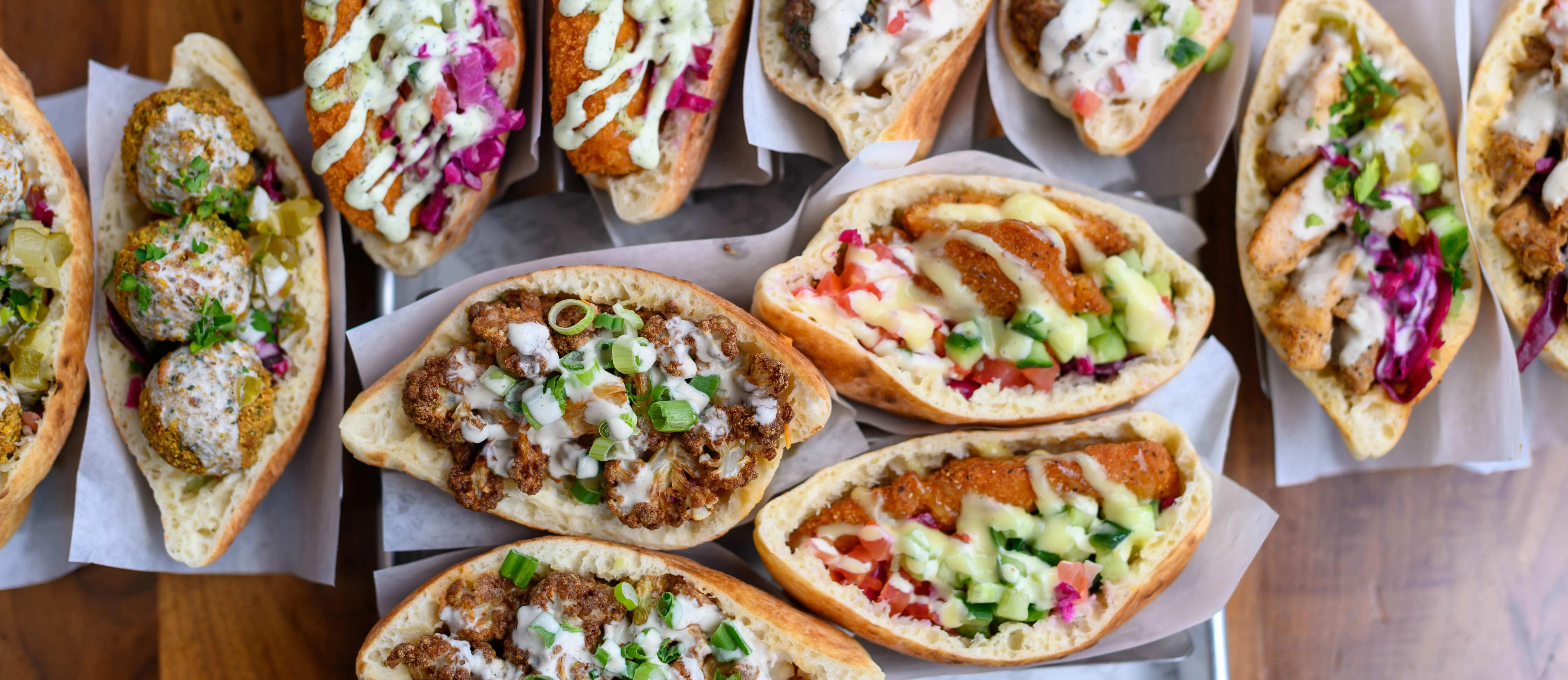 A platter of various pita bread displayed for a large group of customers