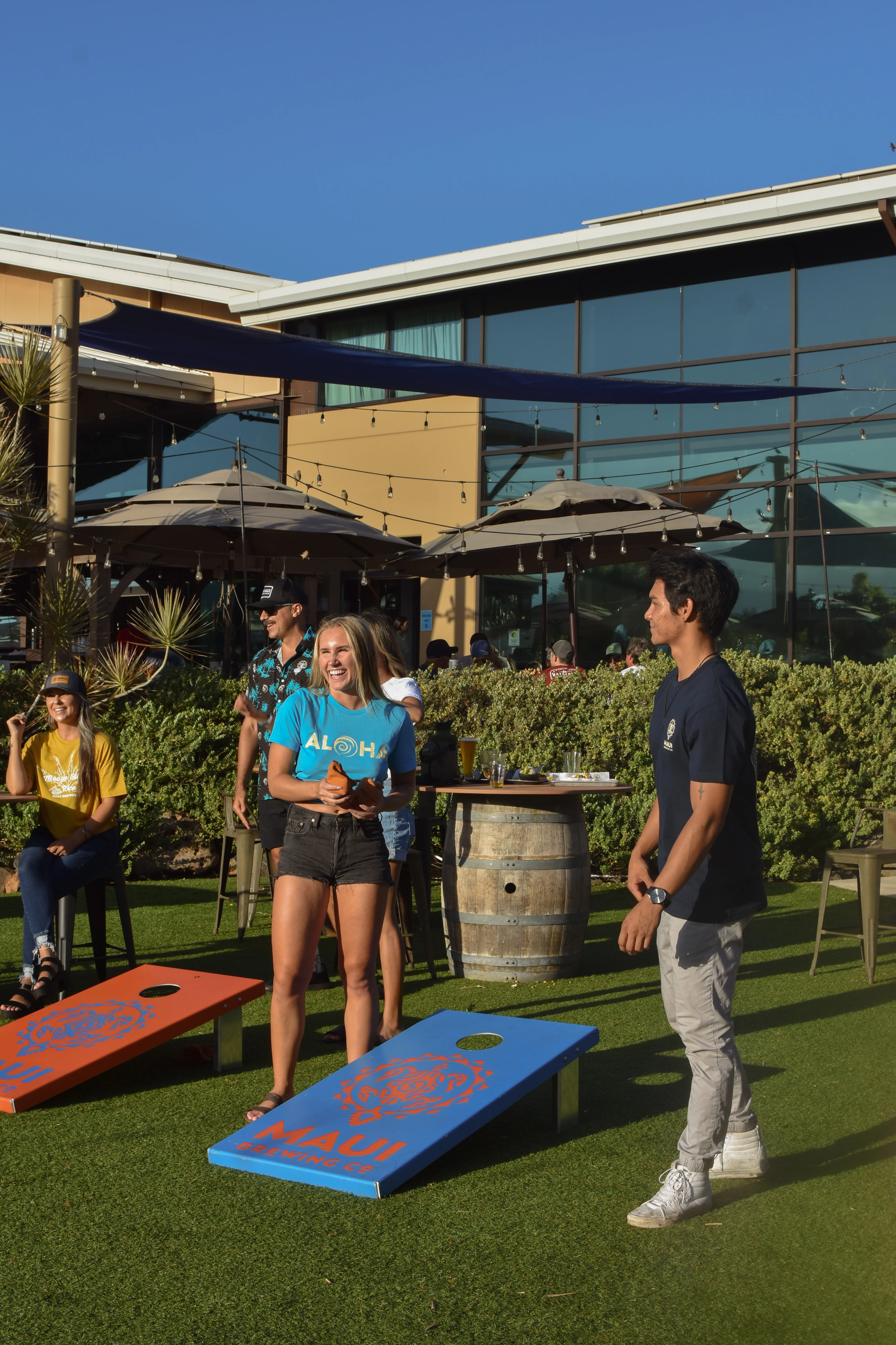Outdoor game area with friends enjoying cornhole at a restaurant