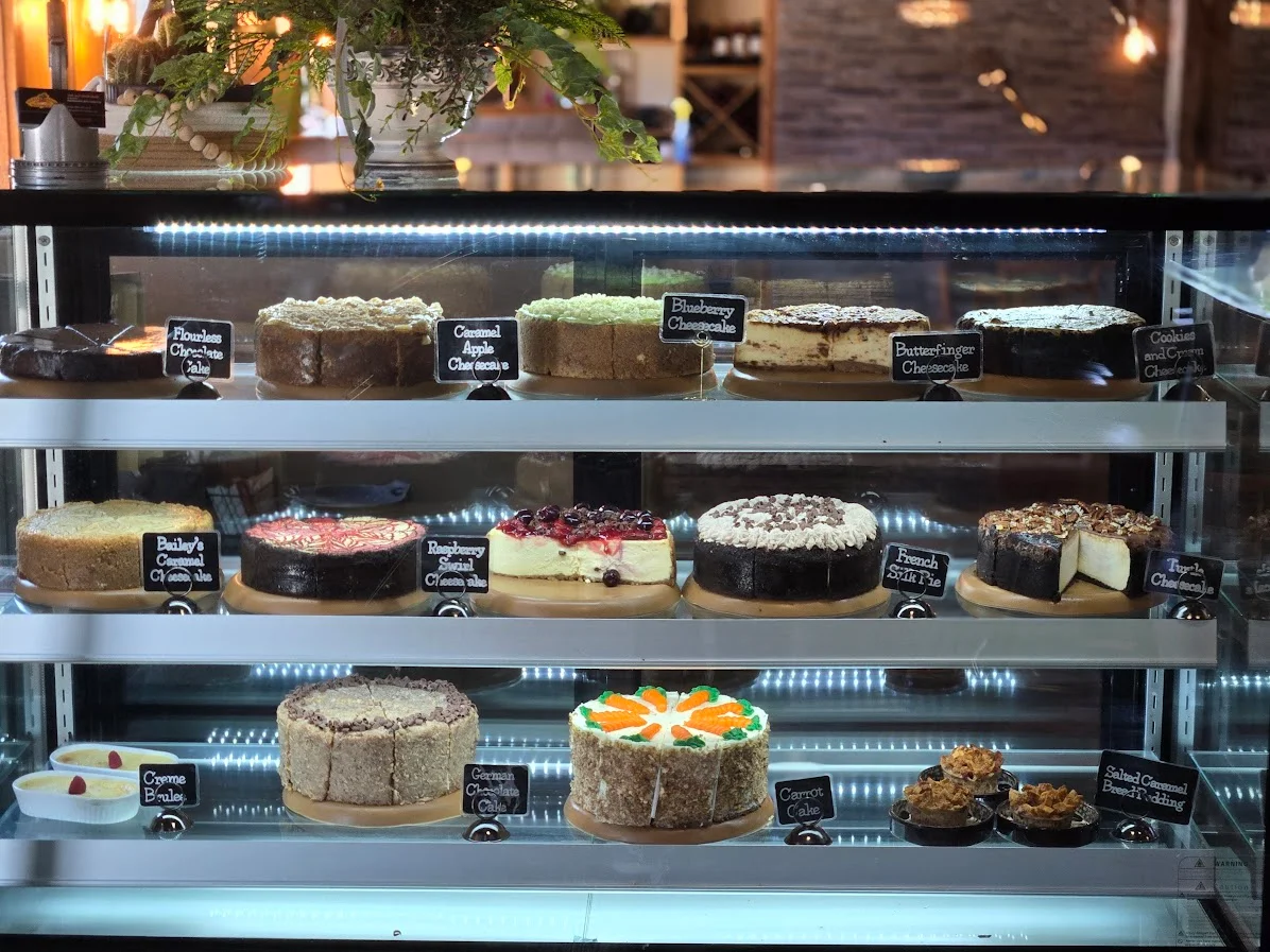 Display of assorted cheesecakes and desserts in a bakery case