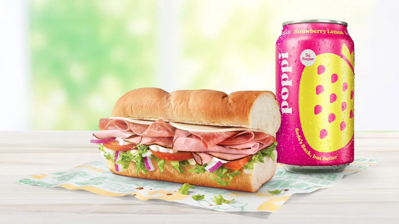 Italian sub sandwich with deli meats and a refreshing soda