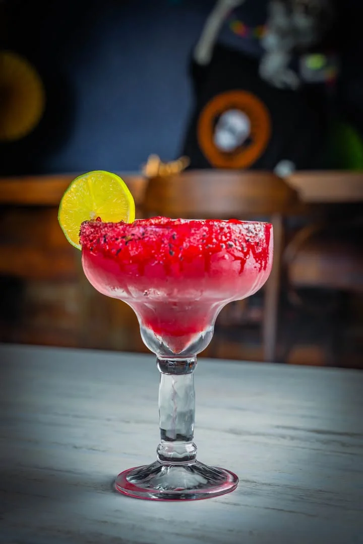 Vibrant margarita cocktail with raspberry and lime garnish