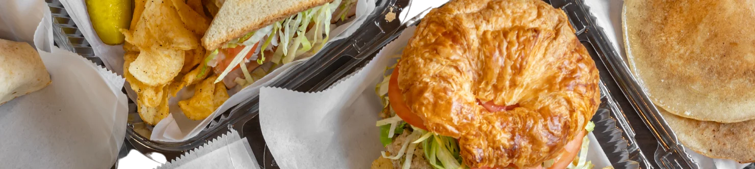 Assorted sandwiches and sides in takeout containers