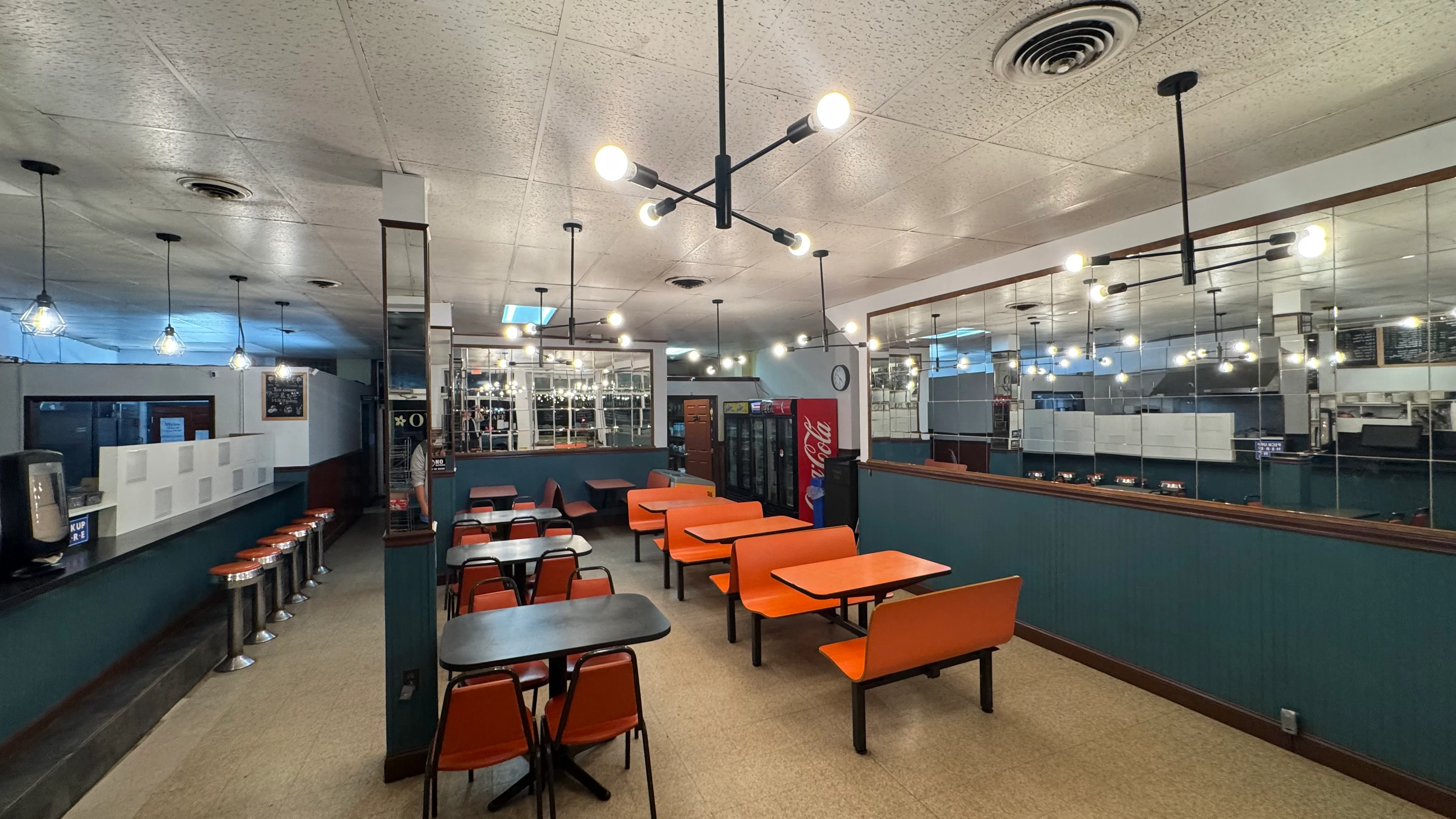 Cozy restaurant interior with modern lighting and orange seating