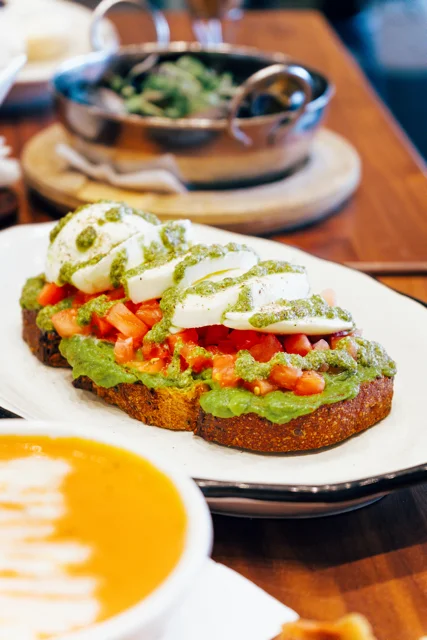 Avocado toast with poached eggs and pesto drizzle