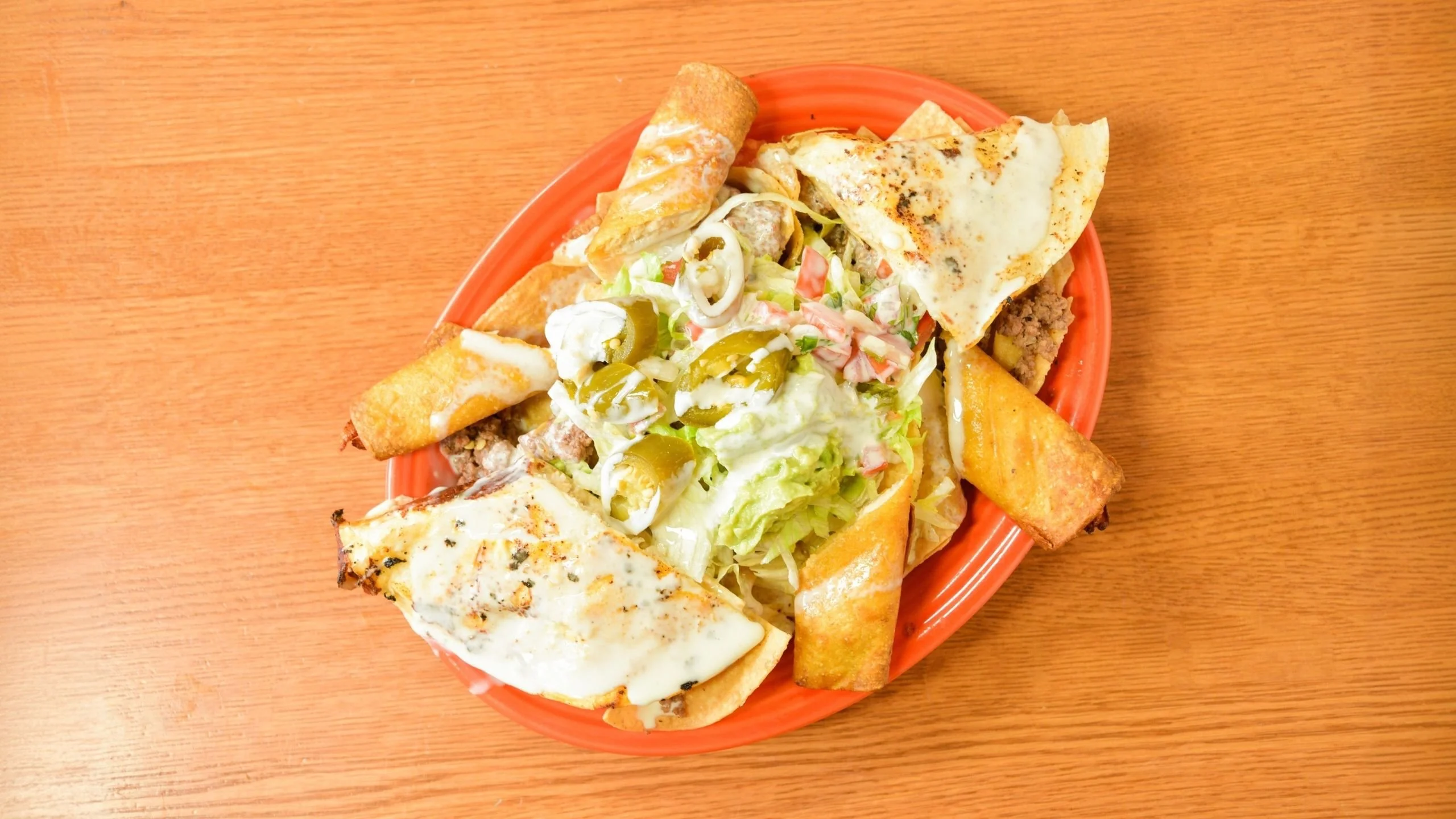 Plate of Mexican enchiladas with toppings and sides