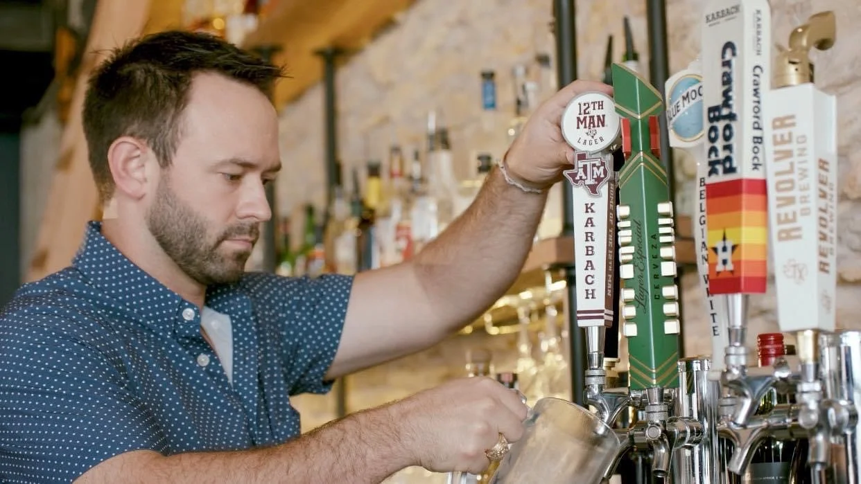 Bartender pouring beer at a lively bar