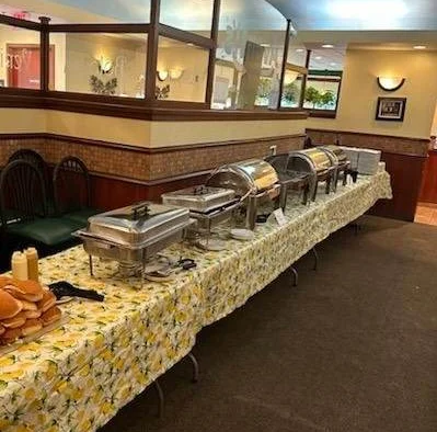 Buffet setup with chafing dishes and rolls in a cozy restaurant