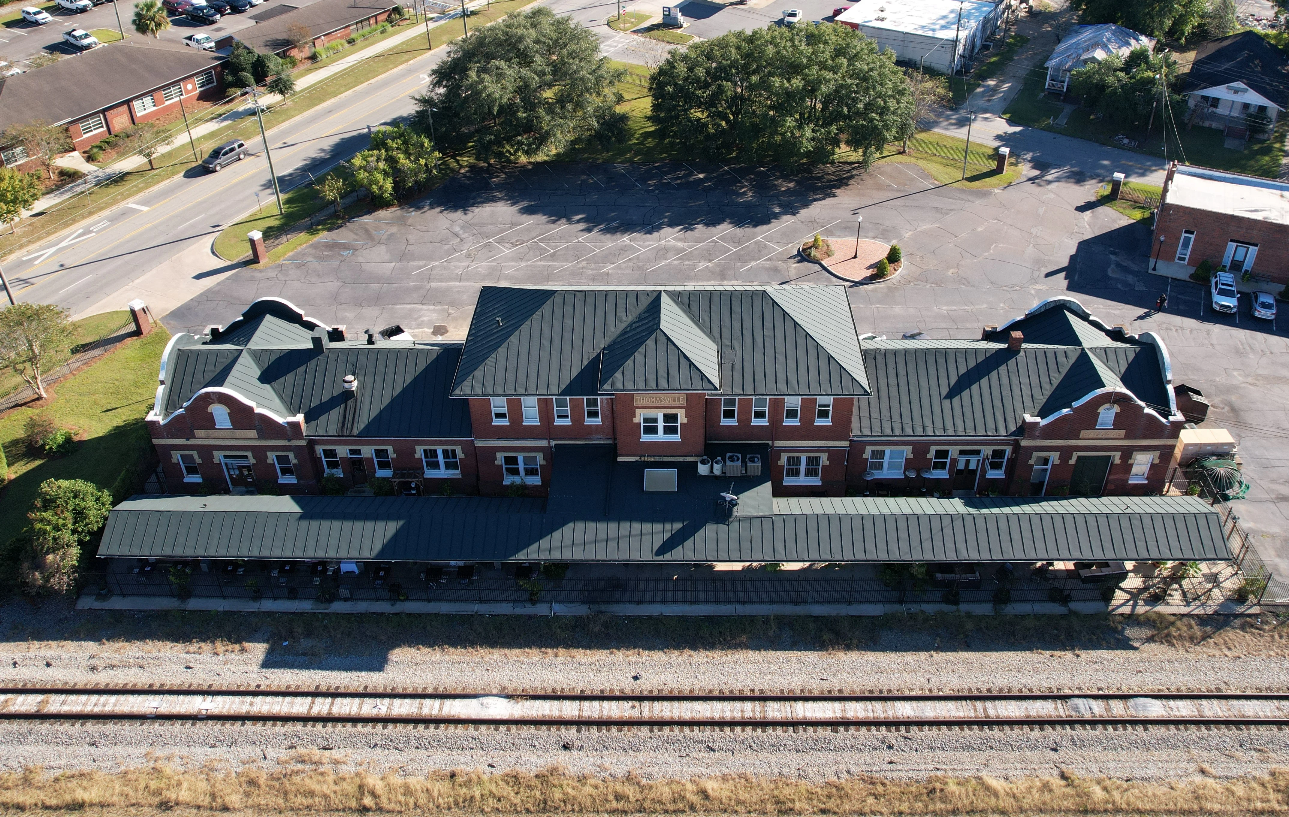 Historic train station building with green roof and outdoor seating