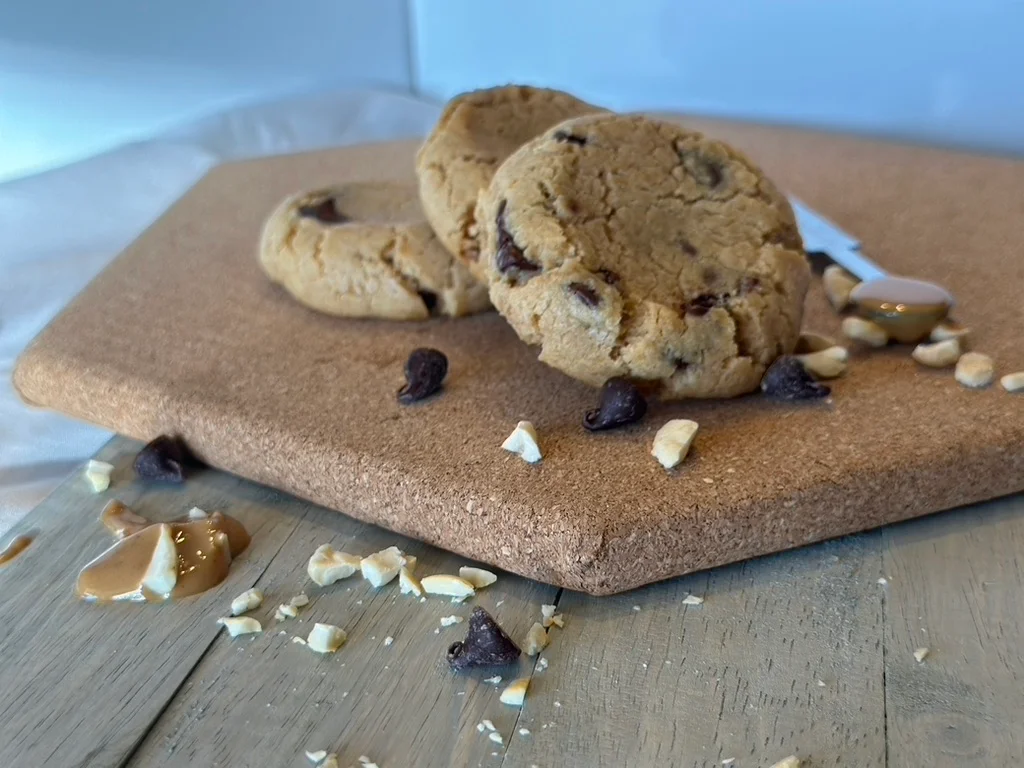 Freshly baked chocolate chip cookies on a wooden board