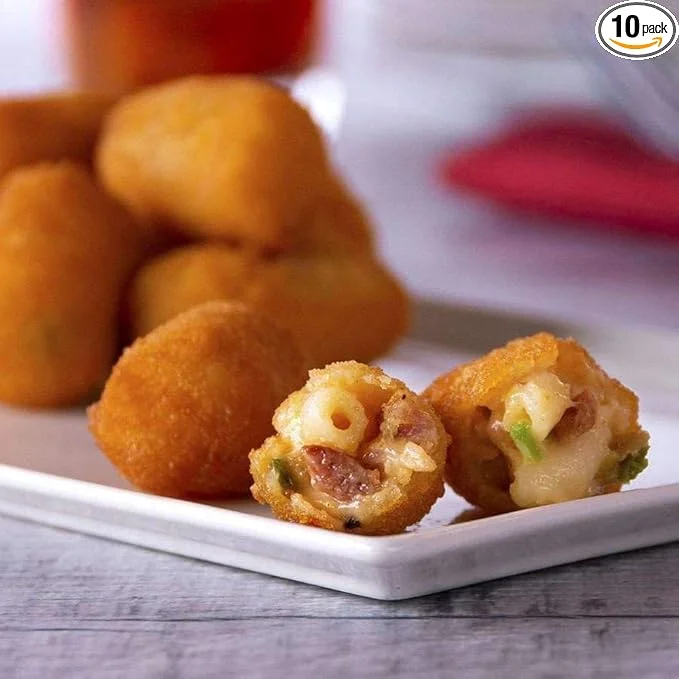 A plate of golden, breaded bites with one cut open to reveal macaroni and cheese filling.