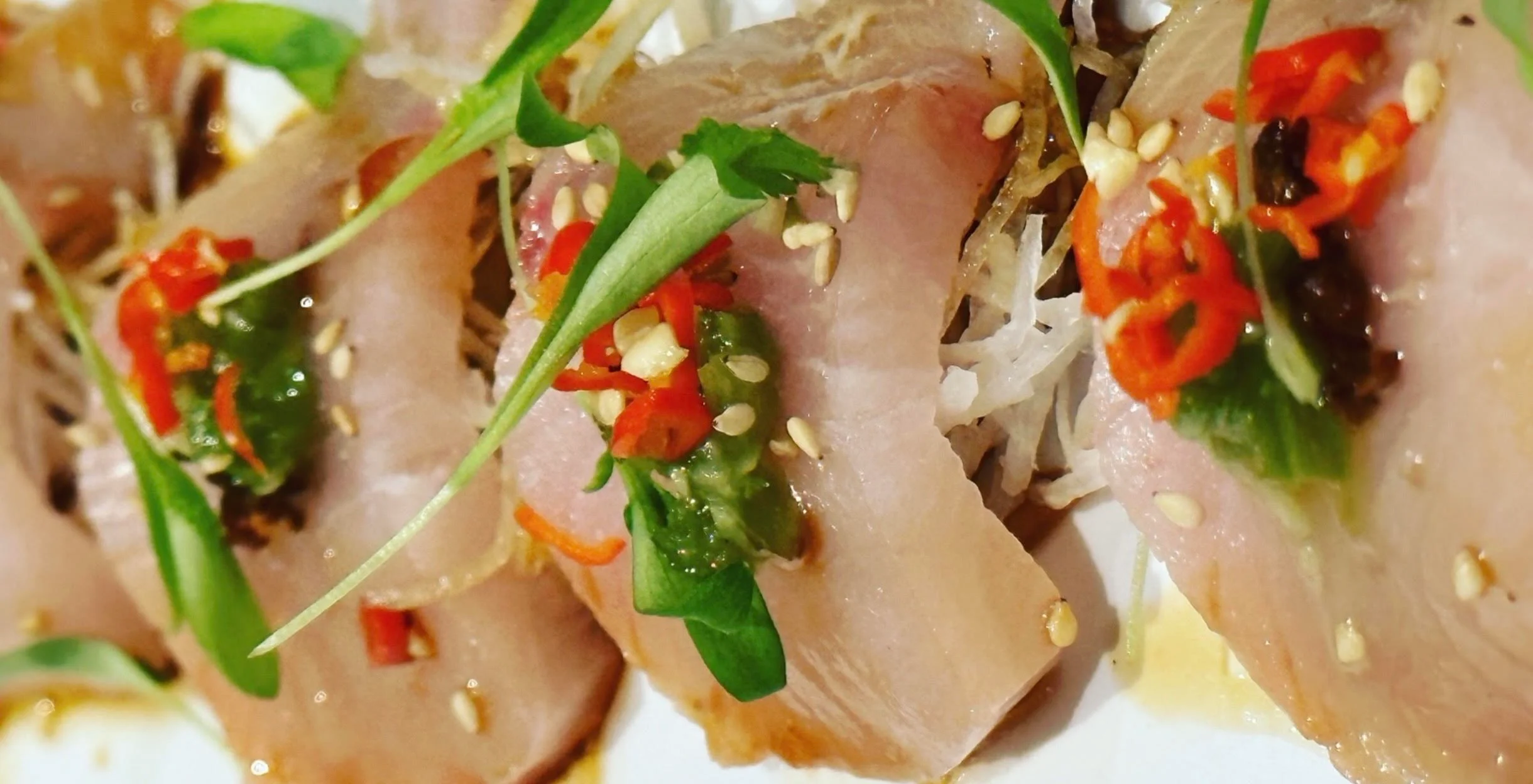Japanese sashimi with spicy garnish and sesame seeds