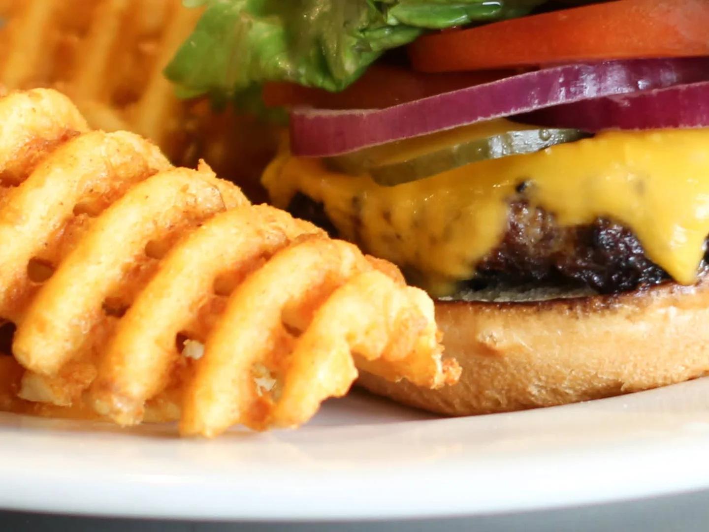 Classic American cheeseburger with waffle fries