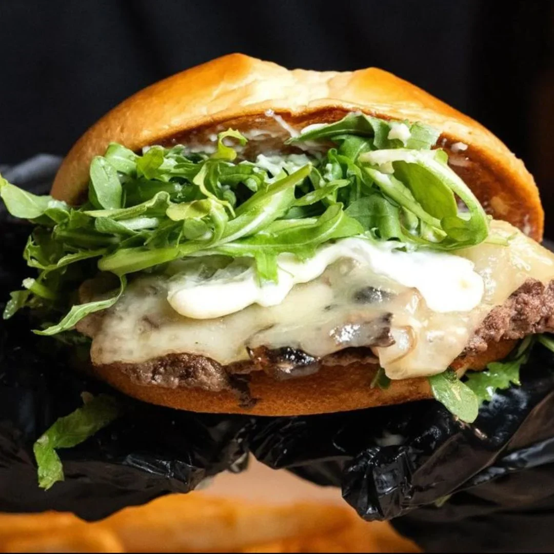 Delicious gourmet burger with fresh toppings on a wooden table