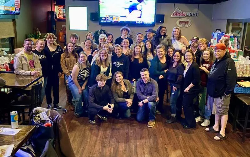 Group photo of a lively restaurant gathering with friends and family