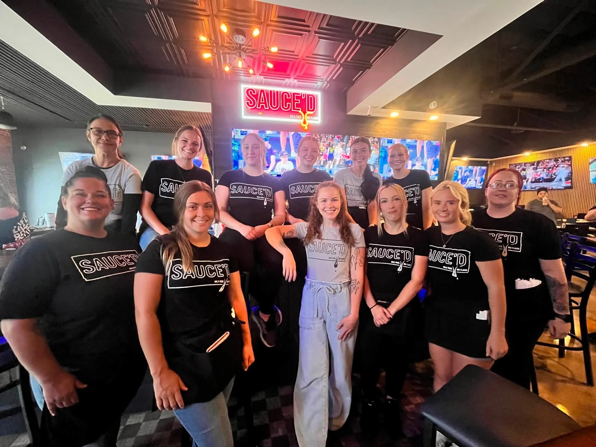 Friendly restaurant staff posing together in a vibrant dining area