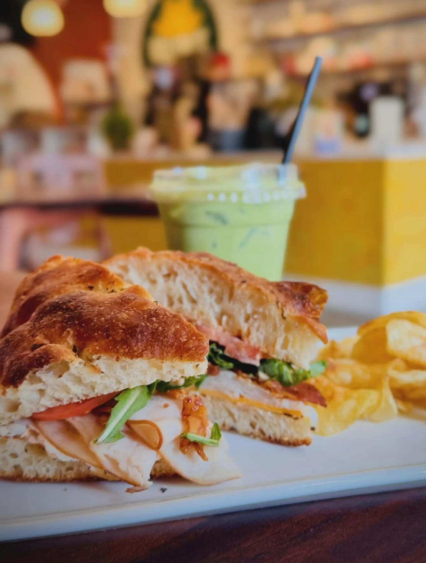 Turkey sandwich with chips in a cozy café setting