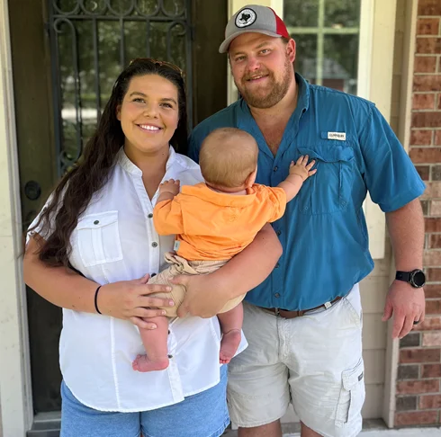 Family portrait with a baby at home entrance