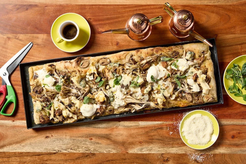 Italian pizza al taglio topped with mushrooms and cheese