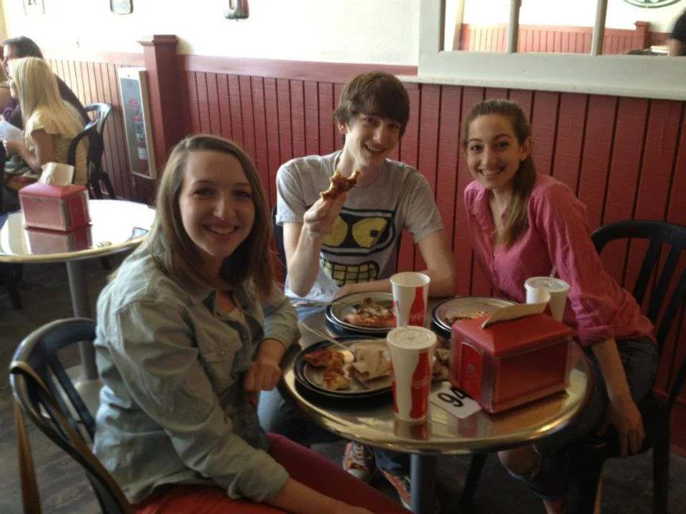 Friends enjoying pizza in a casual restaurant setting
