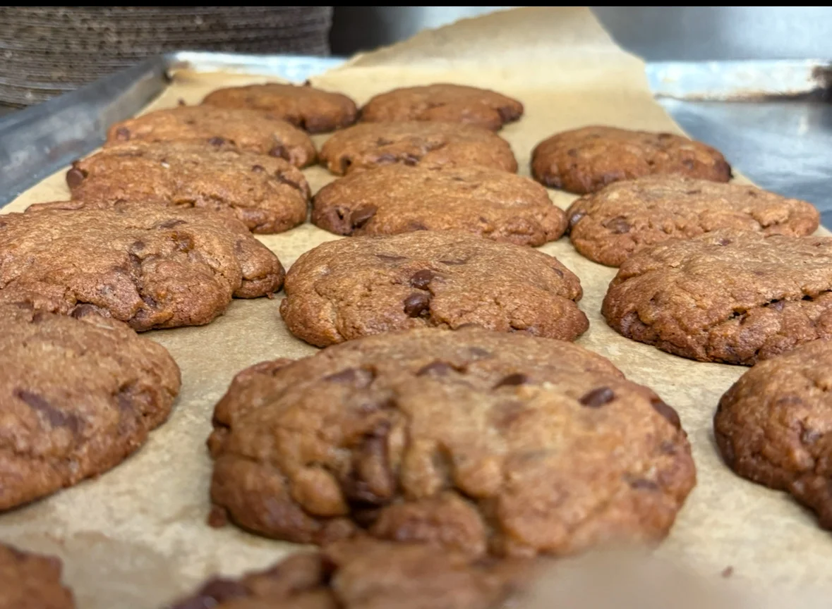 Freshly baked chocolate chip cookies on parchment paper