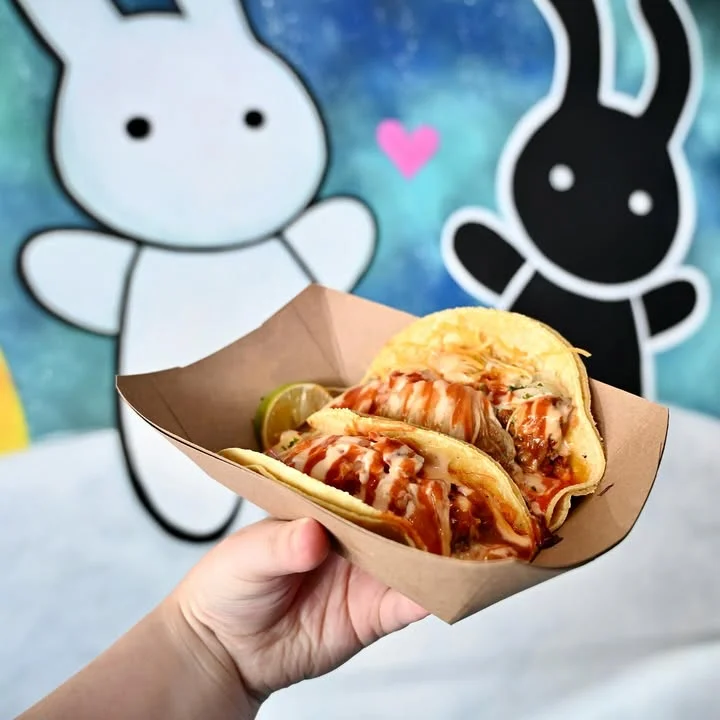 olitoki tacos being held in front of logo wall