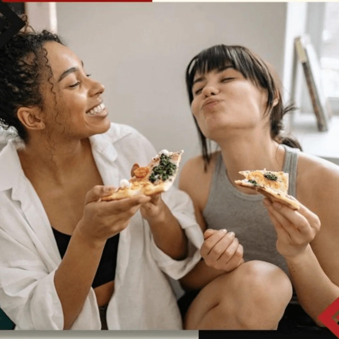 Two friends enjoying slices of pizza together