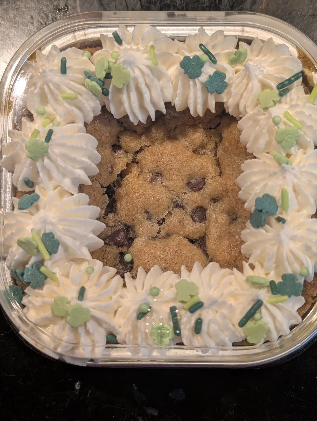 Chocolate chip cookie cake with whipped cream and festive decorations