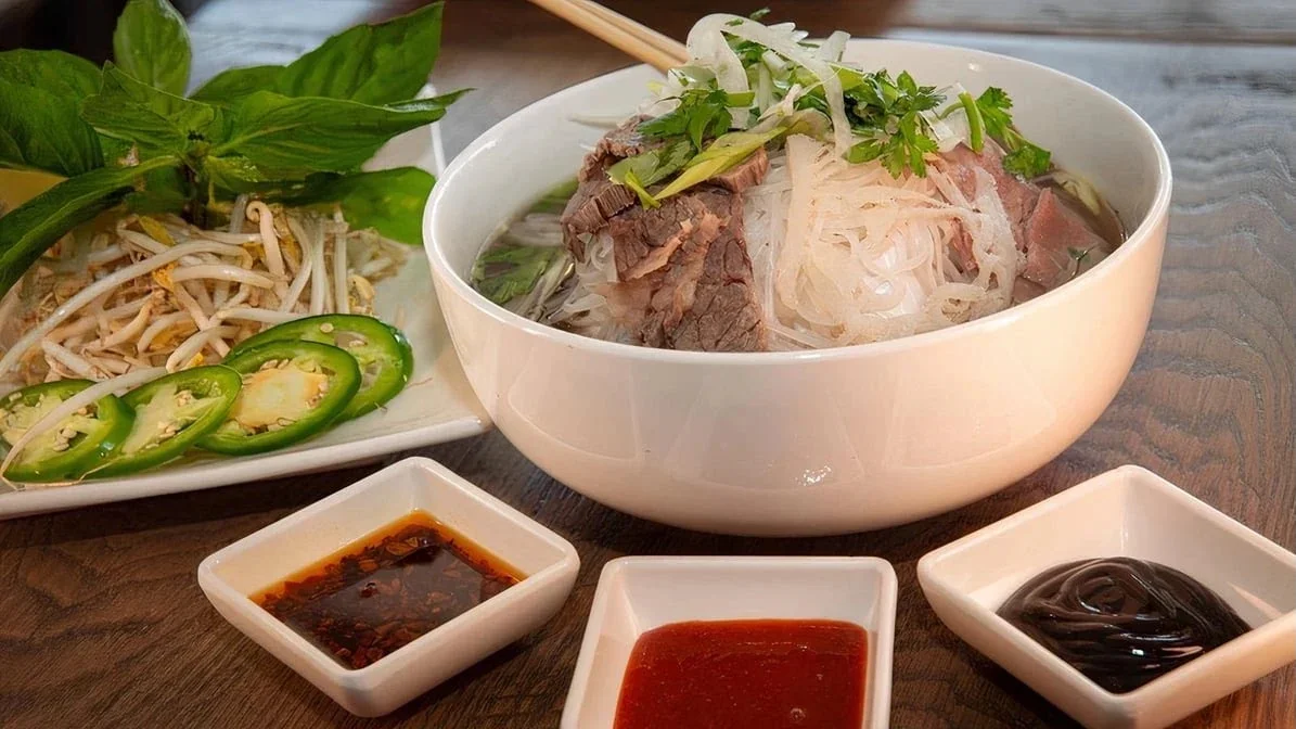 Bowl of Vietnamese pho with beef and fresh herbs