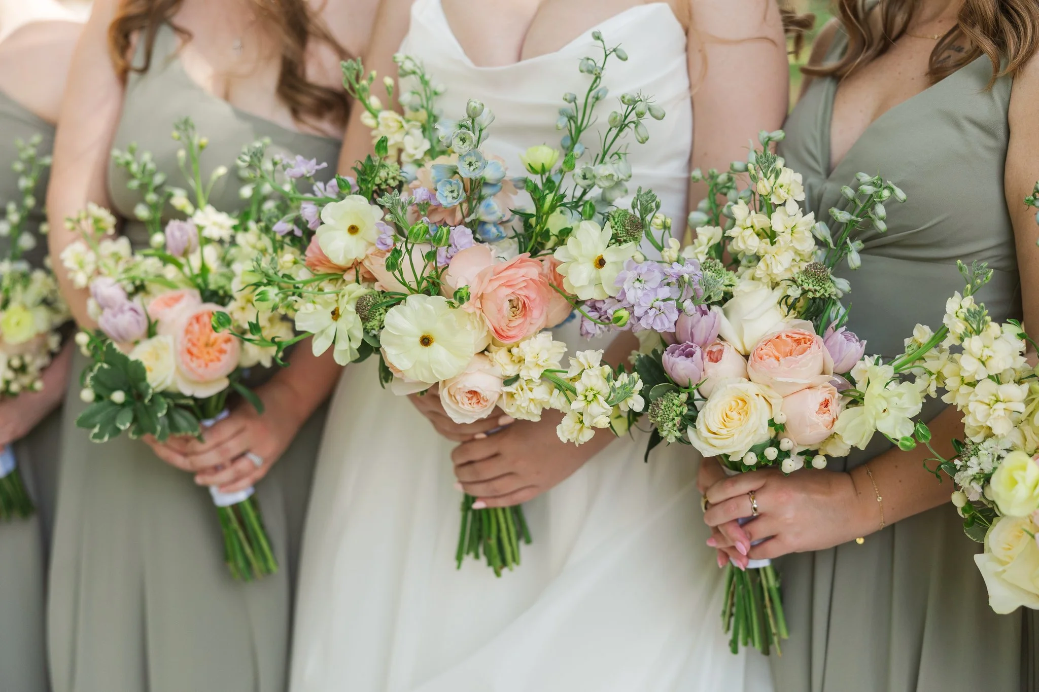 Bridesmaids holding colorful floral bouquets at a wedding